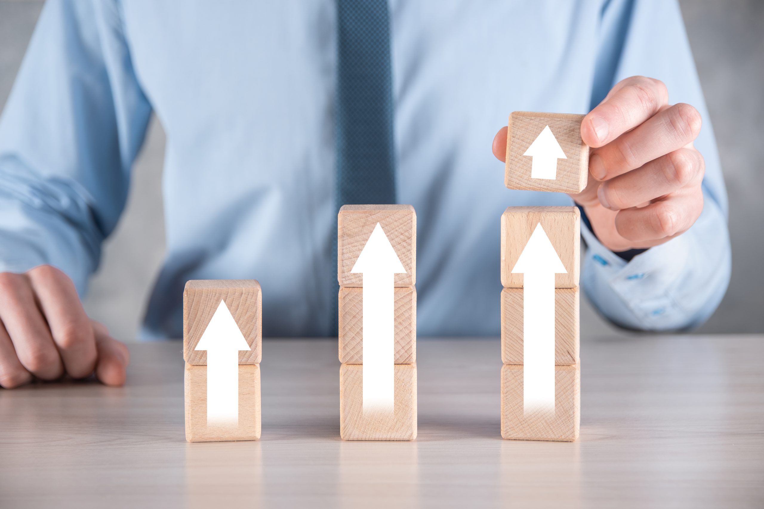 Business development to success and growing growth concept.businessman try to arrange wooden blocks into growing graphs.